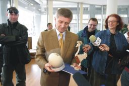 Premier R.P. Marek Belka na aukcji harytatywnej ogląda swą karykaturę wykonaną na jaju strusim